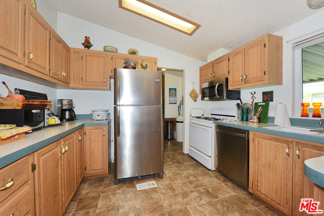 1165 Cherokee Topanga, CA 90290 - Photo 3 of 18 a kitchen with stainless steel appliances granite countertop a refrigerator sink and cabinets