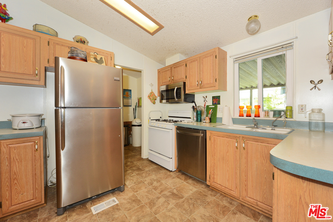 1165 Cherokee Topanga, CA 90290 - Photo 4 of 18 a white refrigerator freezer sitting inside of a kitchen