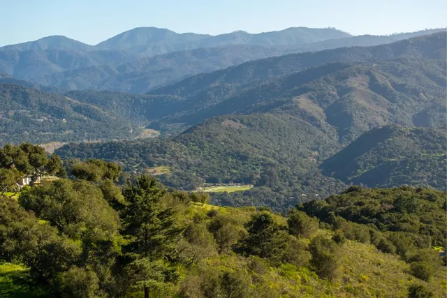a view of a house with a mountain and a forest