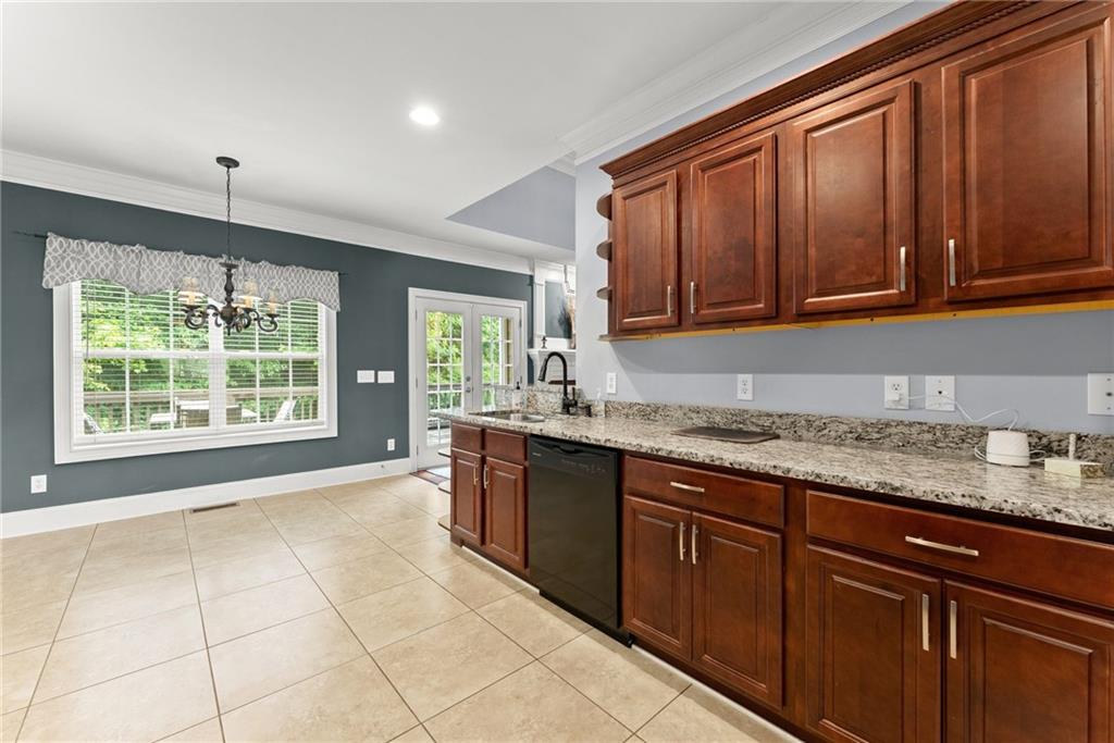 6643 Windvane Point Clermont, GA 30527 - Photo 21 of 88 a kitchen with stainless steel appliances granite countertop wooden cabinets a sink and dishwasher with a large window