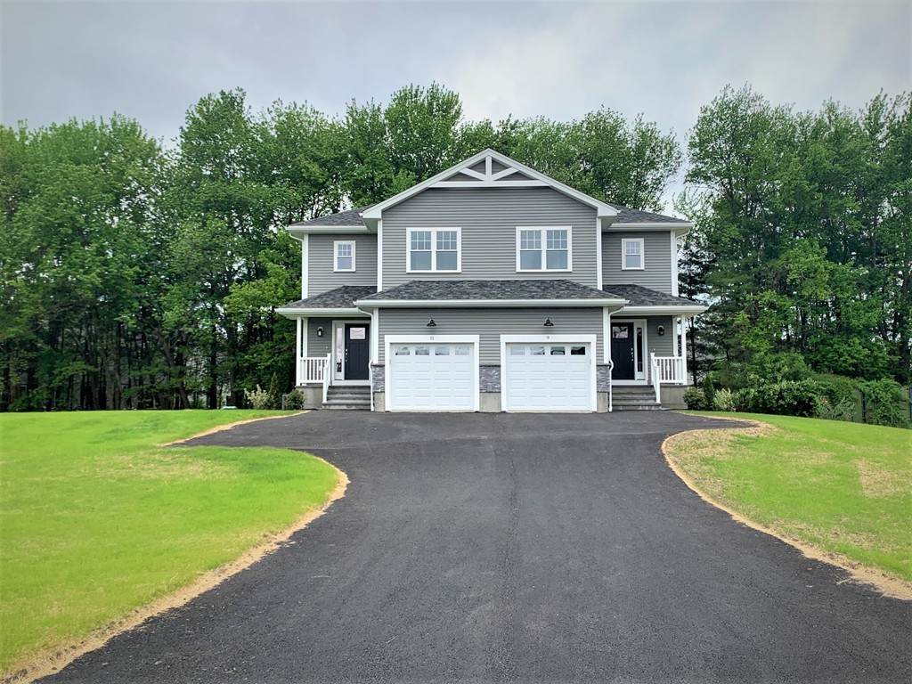 21 Shaker Road, Unit B Ayer, MA 01432 - Photo 1 of 16 a front view of a house with a yard and garage