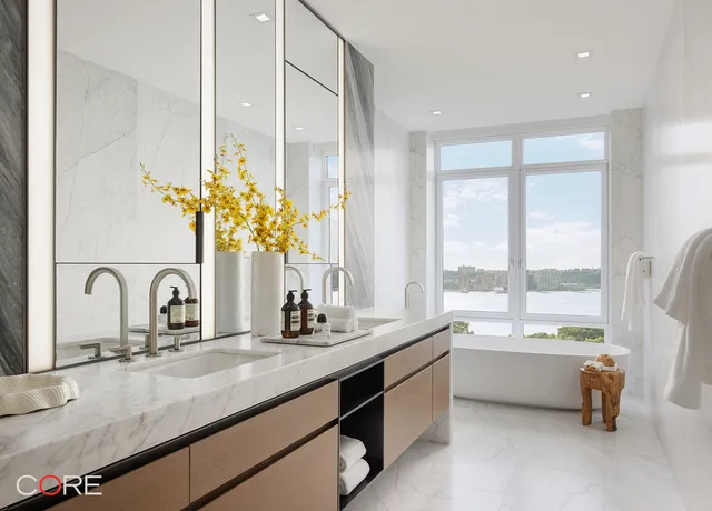 a bathroom with a double vanity sink a mirror and a bathtub