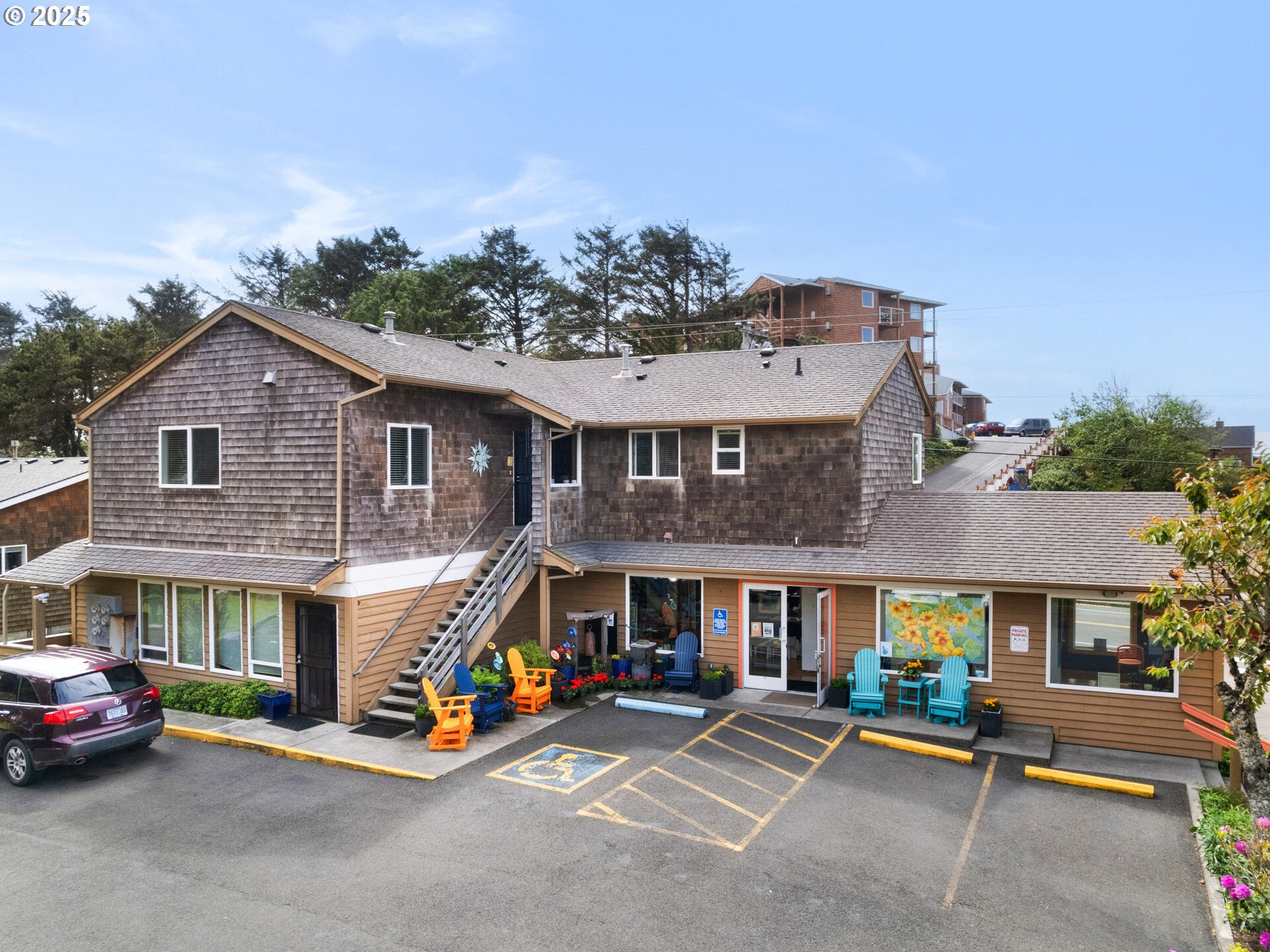 107 Sunset Boulevard Cannon Beach, OR 97110 - Photo 1 of 25 a view of a white house with large windows and a table and chairs