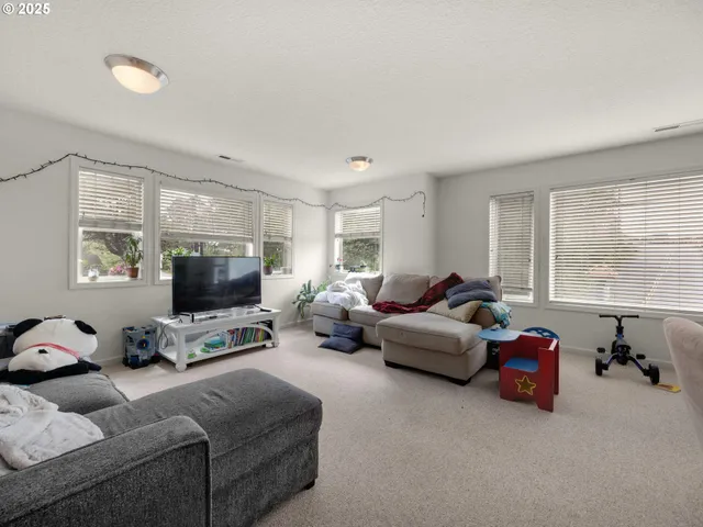 a living room with furniture a window and a flat screen tv