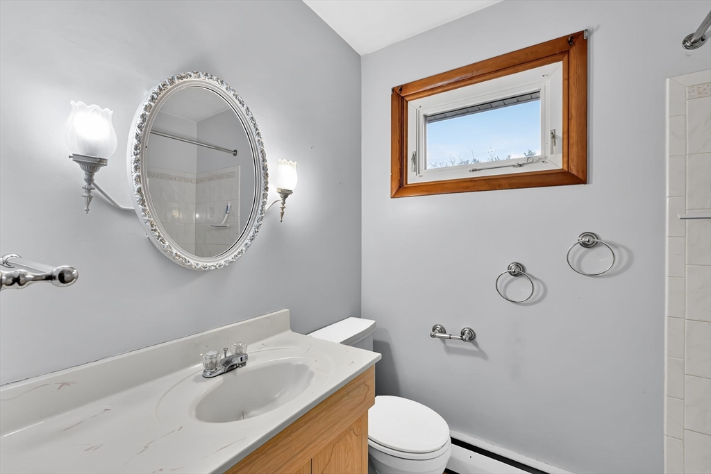 193 Marmon Street Springfield, MA 01129 - Photo 14 of 26 a bathroom with a toilet a sink and mirror