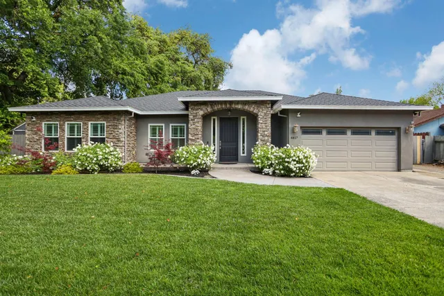 a front view of house with yard and trees in the background