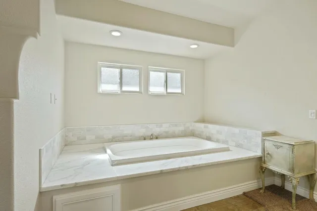 a bathroom with a bathtub and window