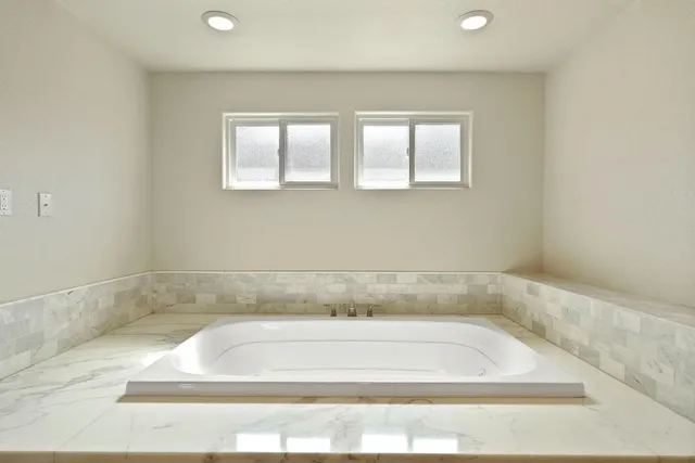 a bath tub sitting in a bathroom next to a window