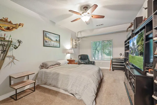 a bedroom with a bed a computer on a desk and chair