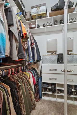 a view of walk in closet with clothes and shoes