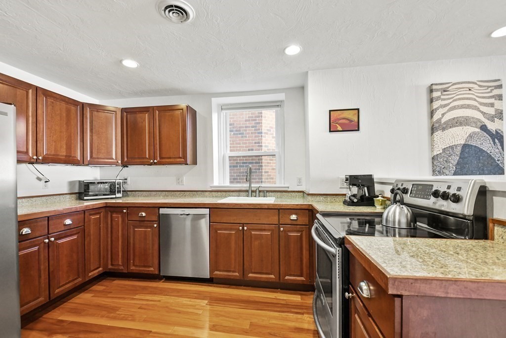 40 Elm Street, Unit 1 Worcester, MA 01609 - Photo 5 of 26 a kitchen with stainless steel appliances granite countertop a sink stove and refrigerator