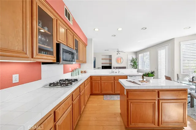 a living room with stainless steel appliances furniture stove and a refrigerator