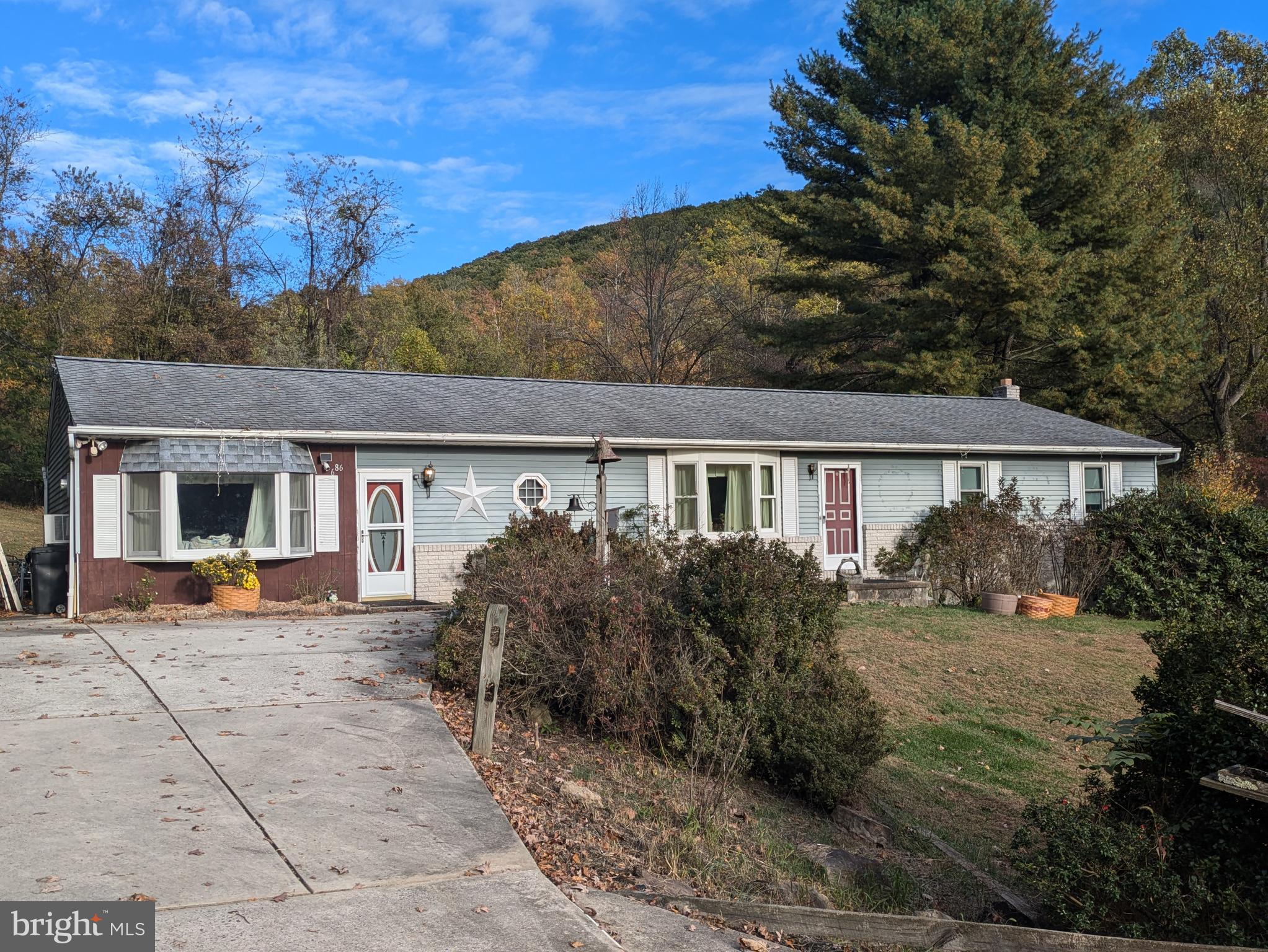 a front view of house with yard and trees in the background
