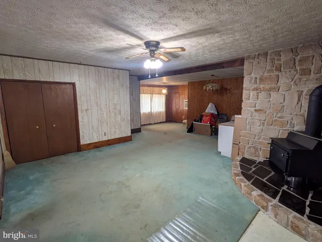 an empty room with windows closet and fireplace