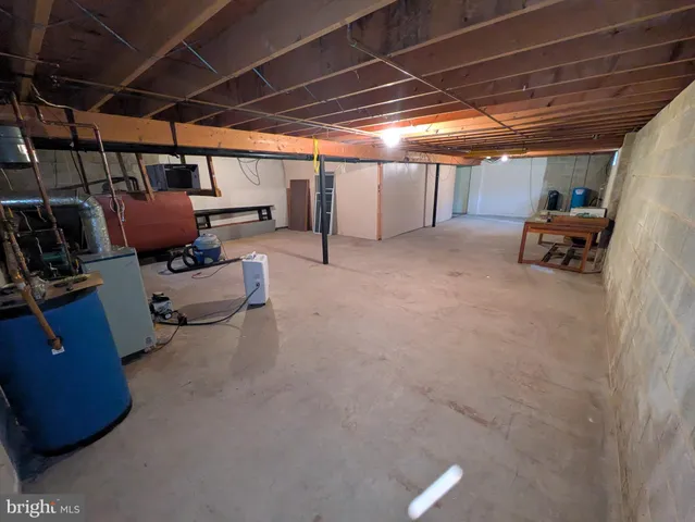 a room with water heater and wooden cabinets