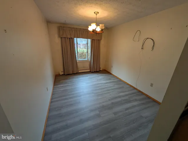 a view of a room with wooden floor and chandelier