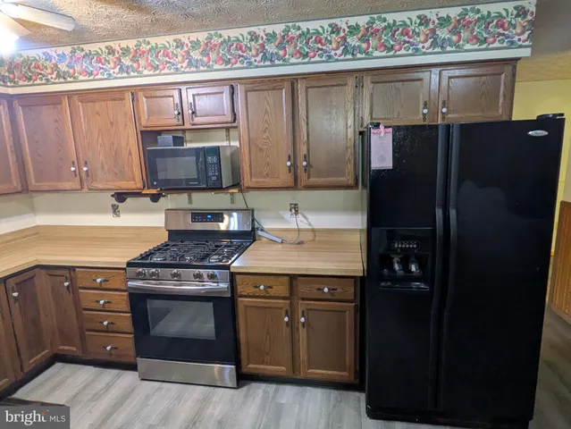 a kitchen with stainless steel appliances granite countertop a stove a refrigerator and a microwave