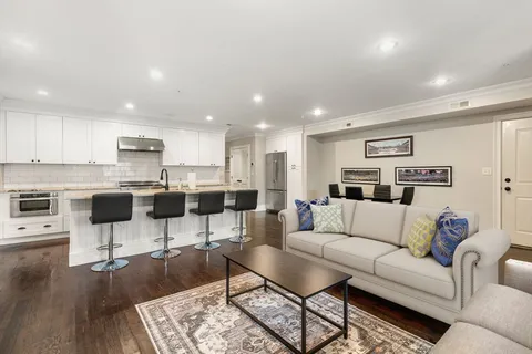 a living room with furniture and kitchen view