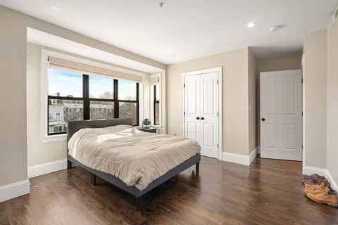 a bedroom with a bed and a large window