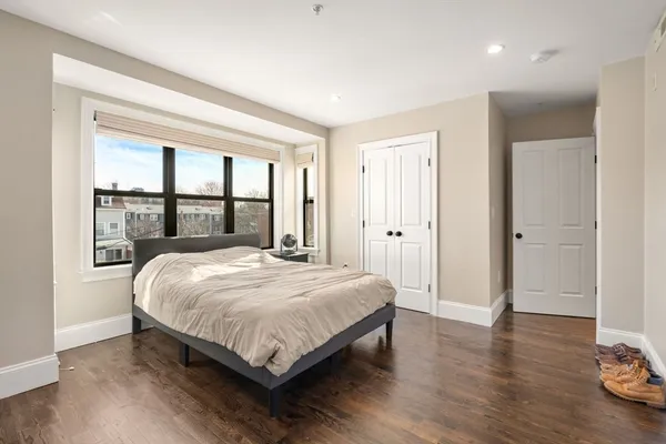 a bedroom with a bed and a large window