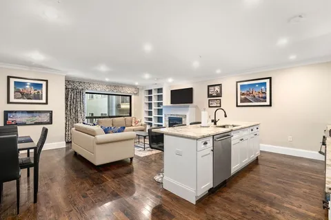 a view of living room with kitchen island furniture and flat screen tv