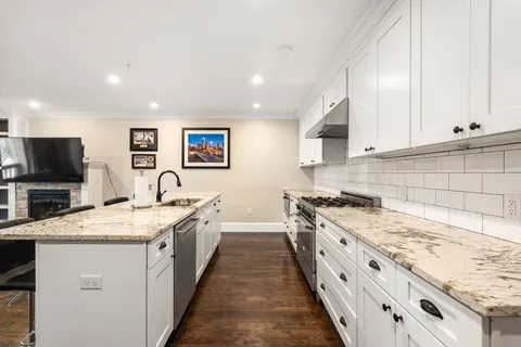 a large kitchen with stainless steel appliances granite countertop a stove sink and cabinets