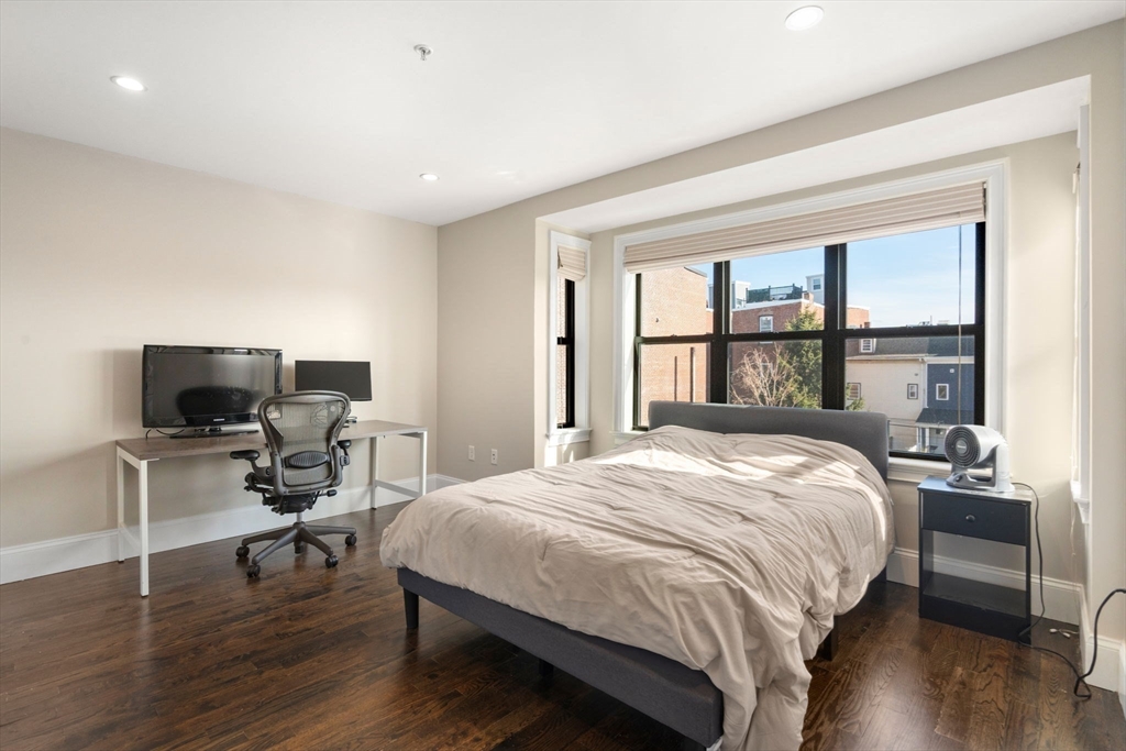 215 Athens Street, Unit 4 Boston, MA 02127 - Photo 10 of 19 a bedroom with a bed and a flat screen tv