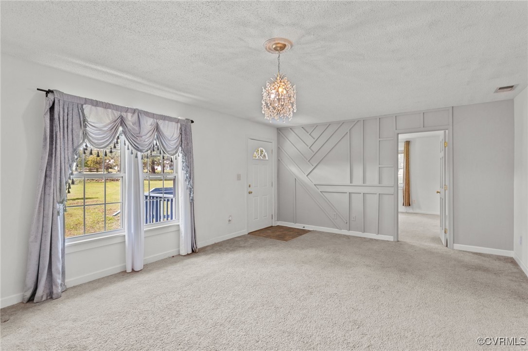 11021 Cosby Mill Road Quinton, VA 23141 - Photo 8 of 43 Empty room with a notable chandelier, a textured c