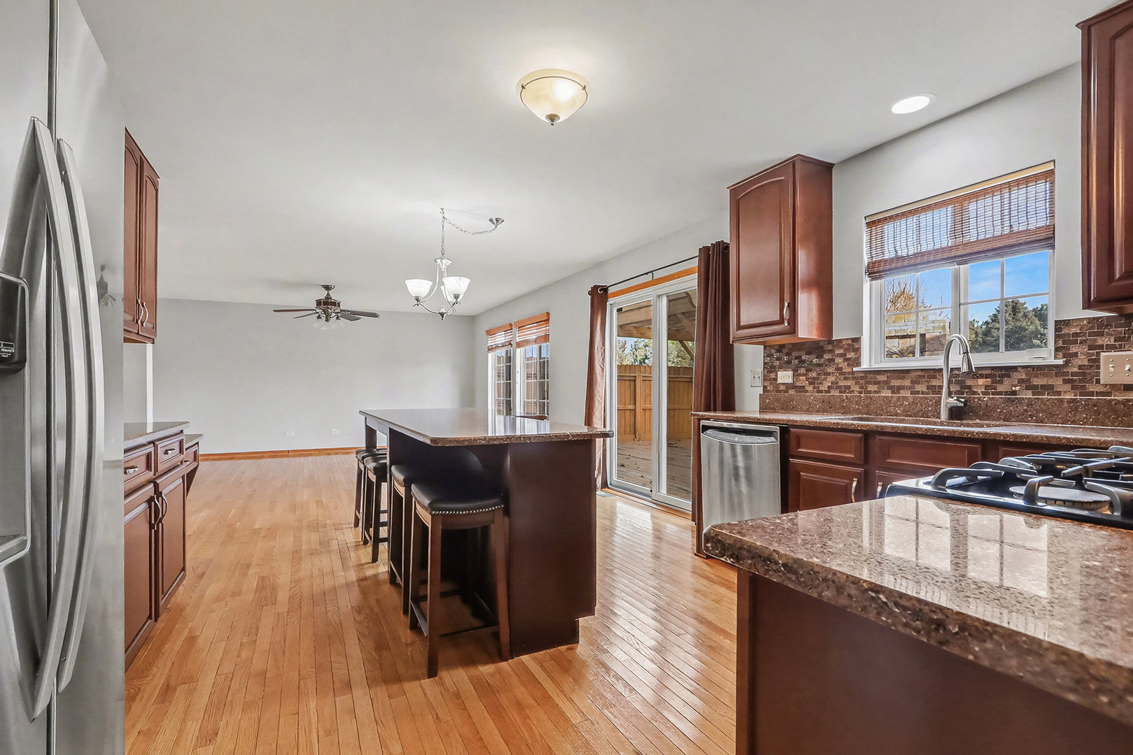 1576 Marigold Lane Minooka, IL 60447 - Photo 7 of 25 a kitchen with stainless steel appliances granite countertop a refrigerator a stove and a wooden floors