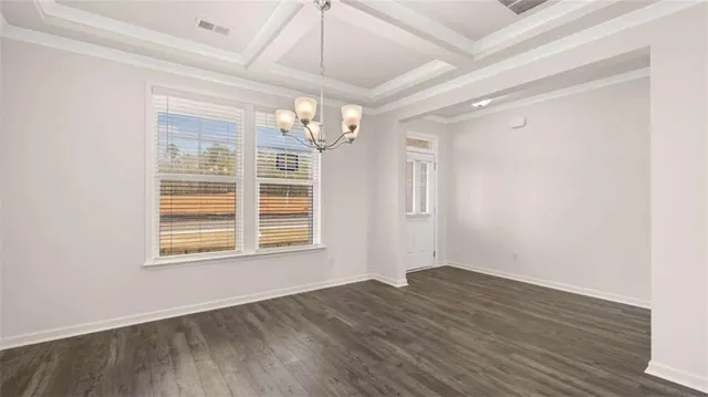 a view of a hallway with wooden floor and a chandelier