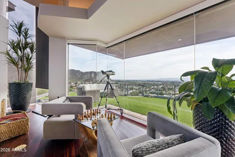 a living room with furniture potted plant and kitchen view