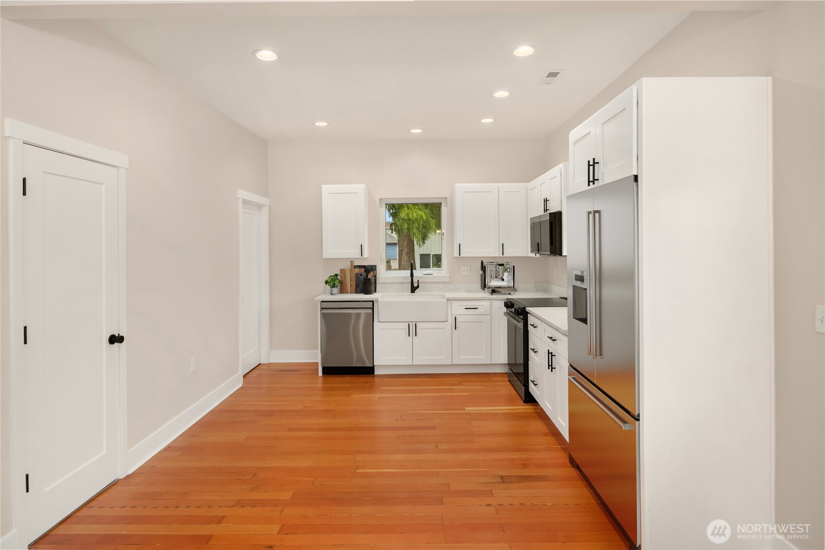 306 3rd Street Sultan, WA 98294 - Photo 11 of 40 a kitchen with white cabinets and white appliances