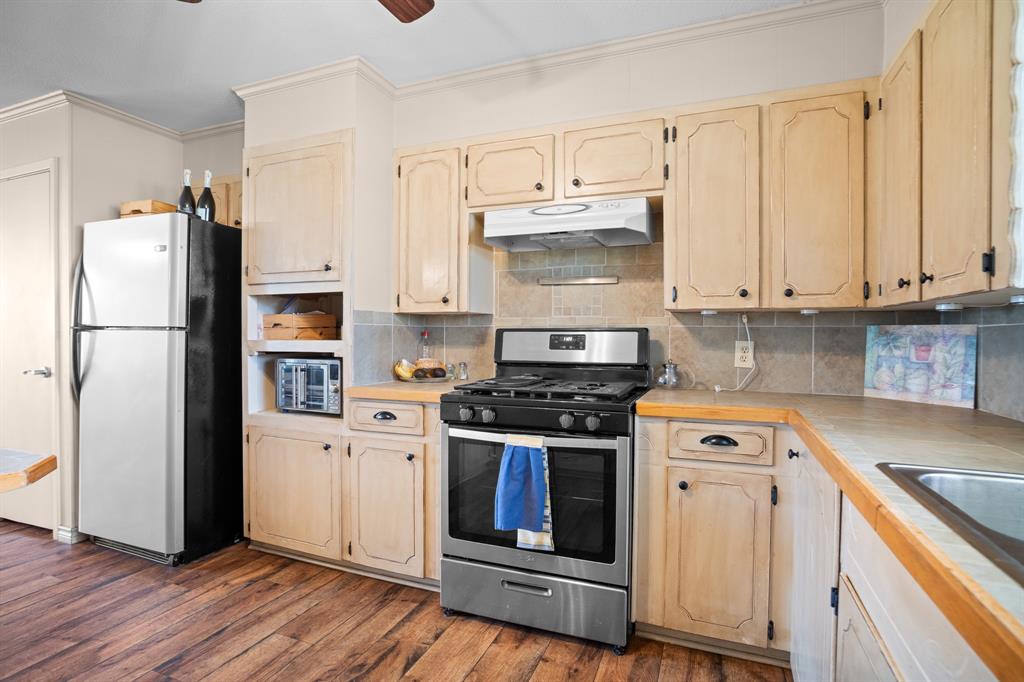 101 Taylor Street Como, TX 75431 - Photo 14 of 39 a kitchen with a stove refrigerator and microwave