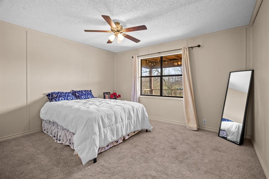 101 Taylor Street Como, TX 75431 - Photo 19 of 39 a spacious bedroom with a bed and a large window