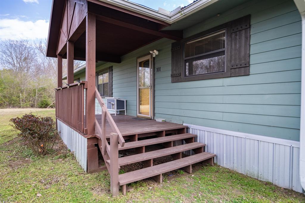 101 Taylor Street Como, TX 75431 - Photo 5 of 39 a view of a backyard with stairs and a wooden fence