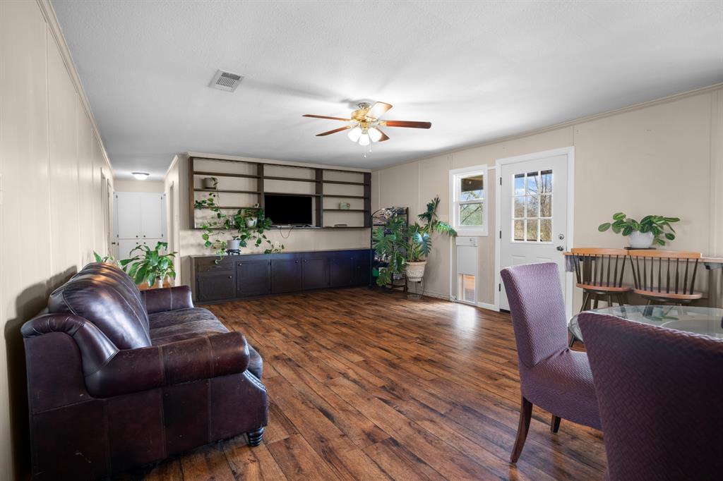 101 Taylor Street Como, TX 75431 - Photo 7 of 39 a living room with furniture a flat screen tv and a potted plant