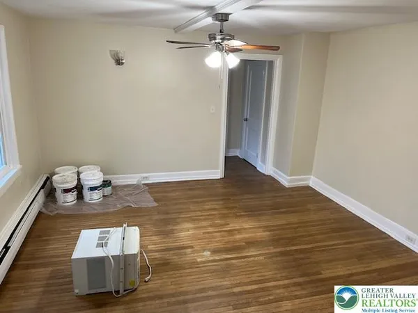 a room with hard wood floor chandelier and windows