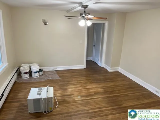 a room with hard wood floor chandelier and windows