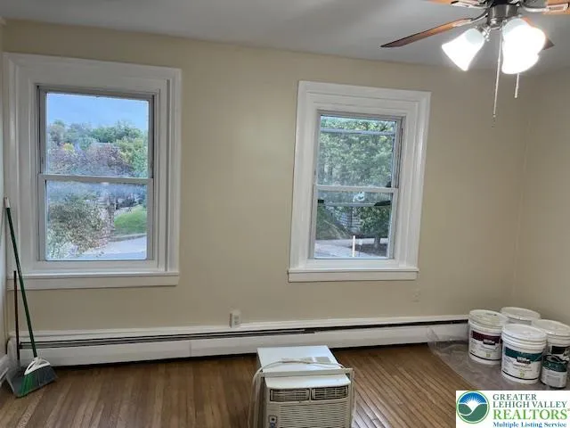 a view of a room with wooden floors and window