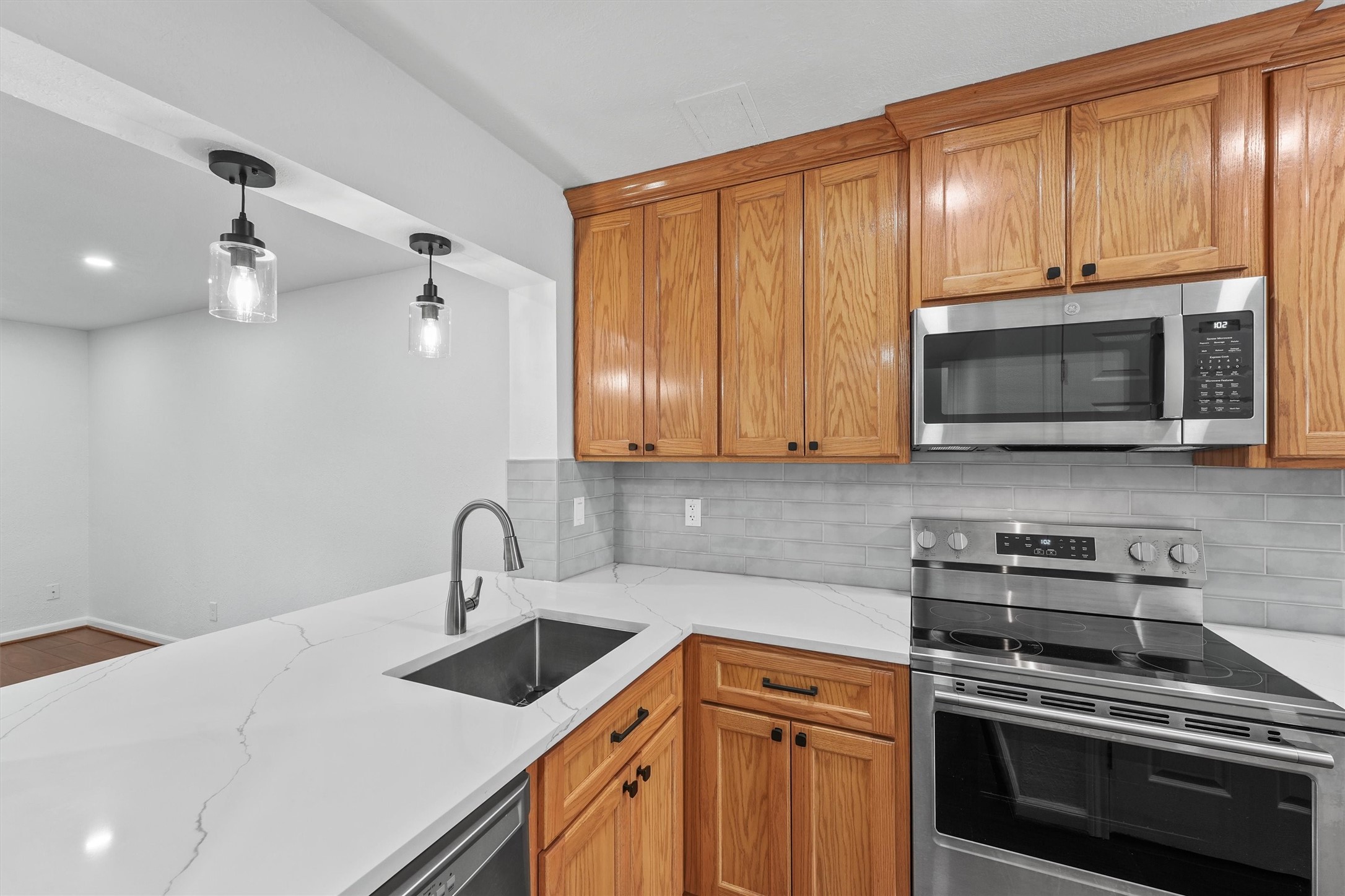 11550 Chimney Rock Road, Unit 536 Houston, TX 77035 - Photo 10 of 28 Breakfast bar in the kitchen with quartz countertops and upgraded pendant lighting