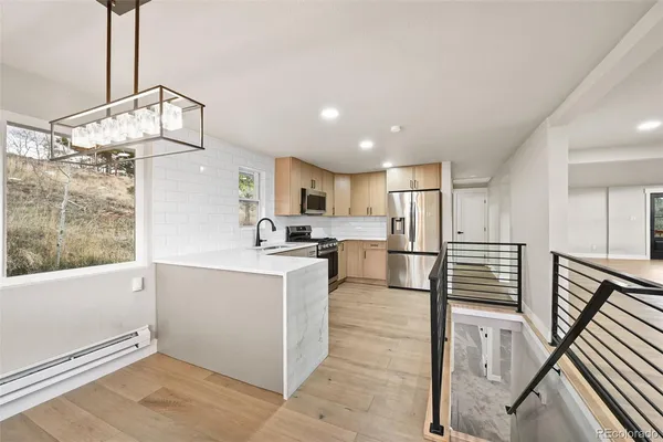 a kitchen with stainless steel appliances kitchen island granite countertop a refrigerator a stove and a sink