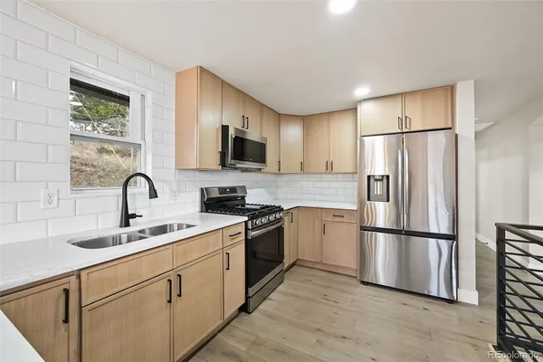 a kitchen with a refrigerator sink and white cabinets