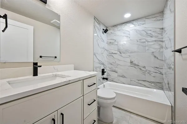 a bathroom with a sink toilet vanity and shower