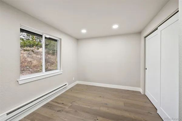 an empty room with wooden floor and windows