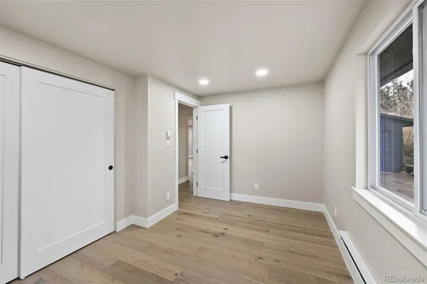 a view of hallway with a large window and wooden floor