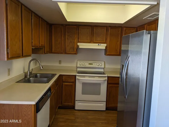 a kitchen with a sink a refrigerator and cabinets
