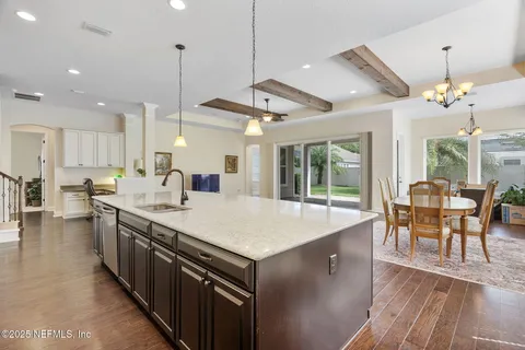 a kitchen with granite countertop a sink a counter top space cabinets and stainless steel appliances