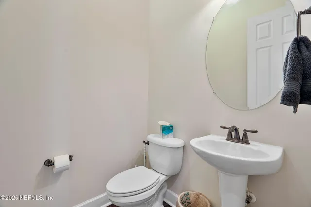 a bathroom with a sink toilet and a mirror