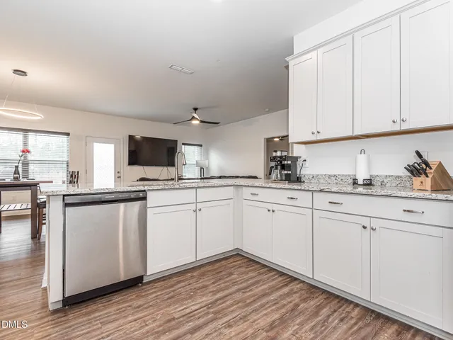 a kitchen with granite countertop white cabinets and white appliances