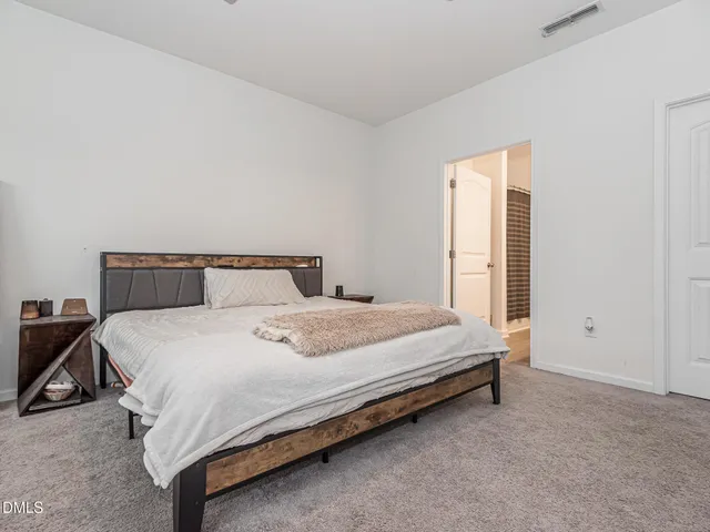 a bedroom with a bed and a night stand